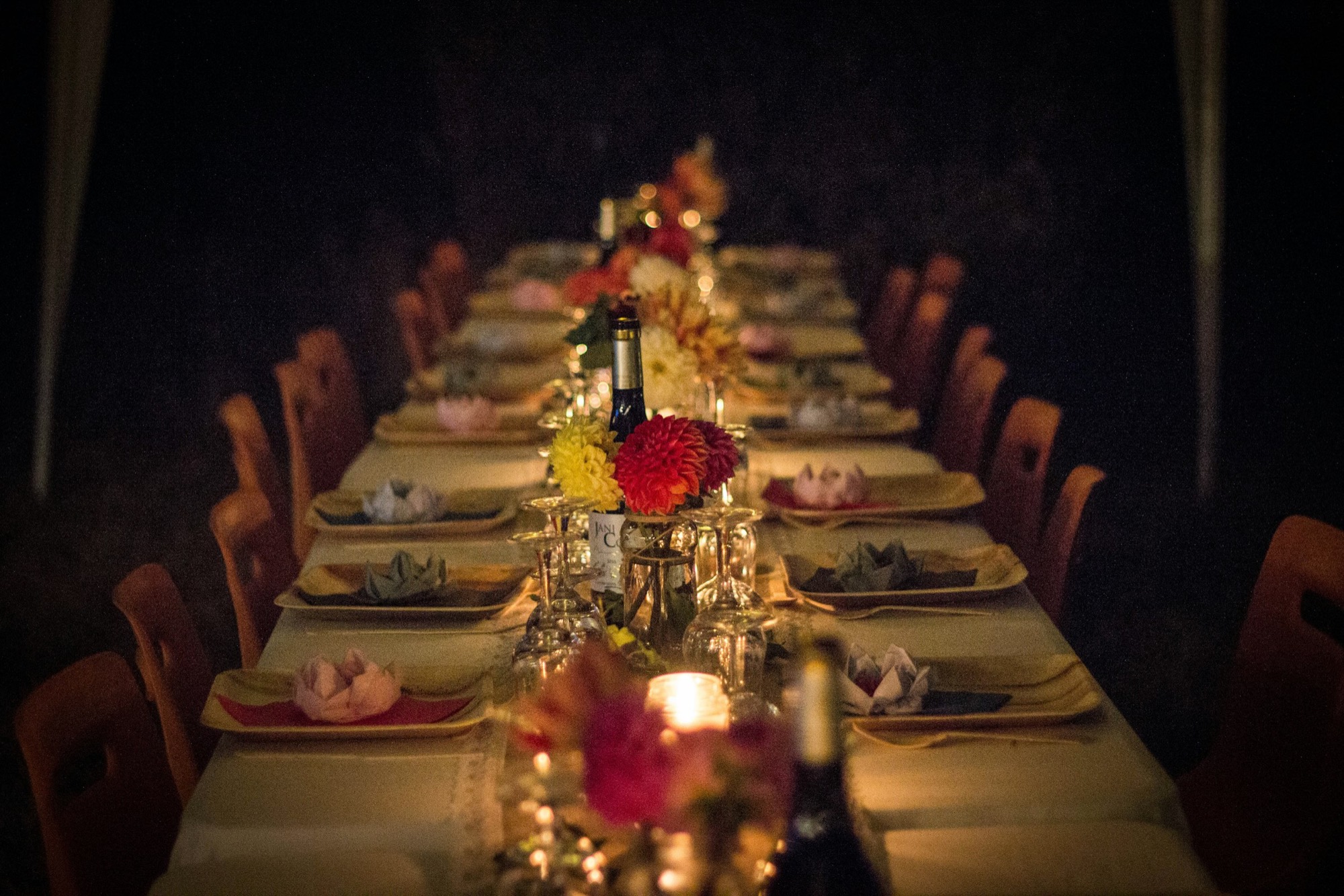 A long dinner table set with flowers and candles